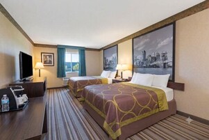 Una habitación de hotel con dos camas, un escritorio con televisor y un cuadro de paisaje urbano en la pared.