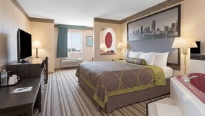 A hotel room with a bed, a desk, a TV, and a bathroom with a bathtub. - Lunar Inn (Wapakoneta)