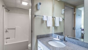 A bathroom with a bathtub, a sink, a towel rack, and a hairdryer.