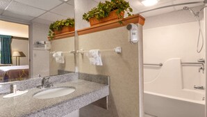A bathroom with two sinks, a mirror, a shower, and a towel rack.