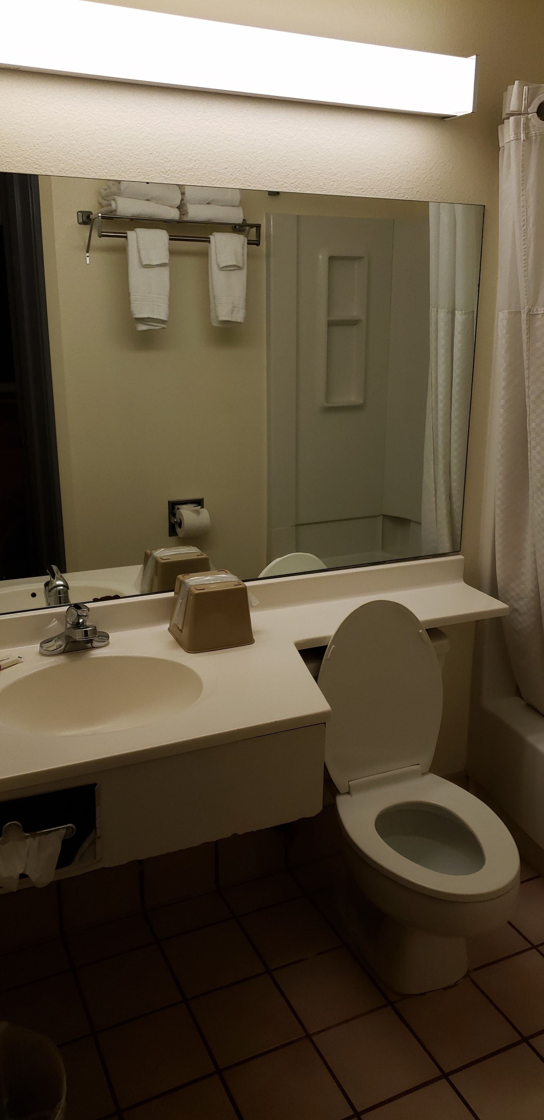 Un baño con lavamanos, inodoro y espejo.