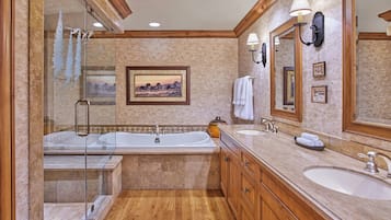 Un baño amplio con una bañera grande, dos lavamanos y una cabina de ducha de vidrio.