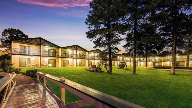 A multi-story hotel with a well-maintained lawn and wooden deck. - Quality Inn Payson (Payson)