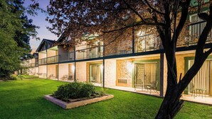 A modern hotel with a well-maintained lawn, outdoor seating, and a balcony with a railing. - Quality Inn Payson (Payson)