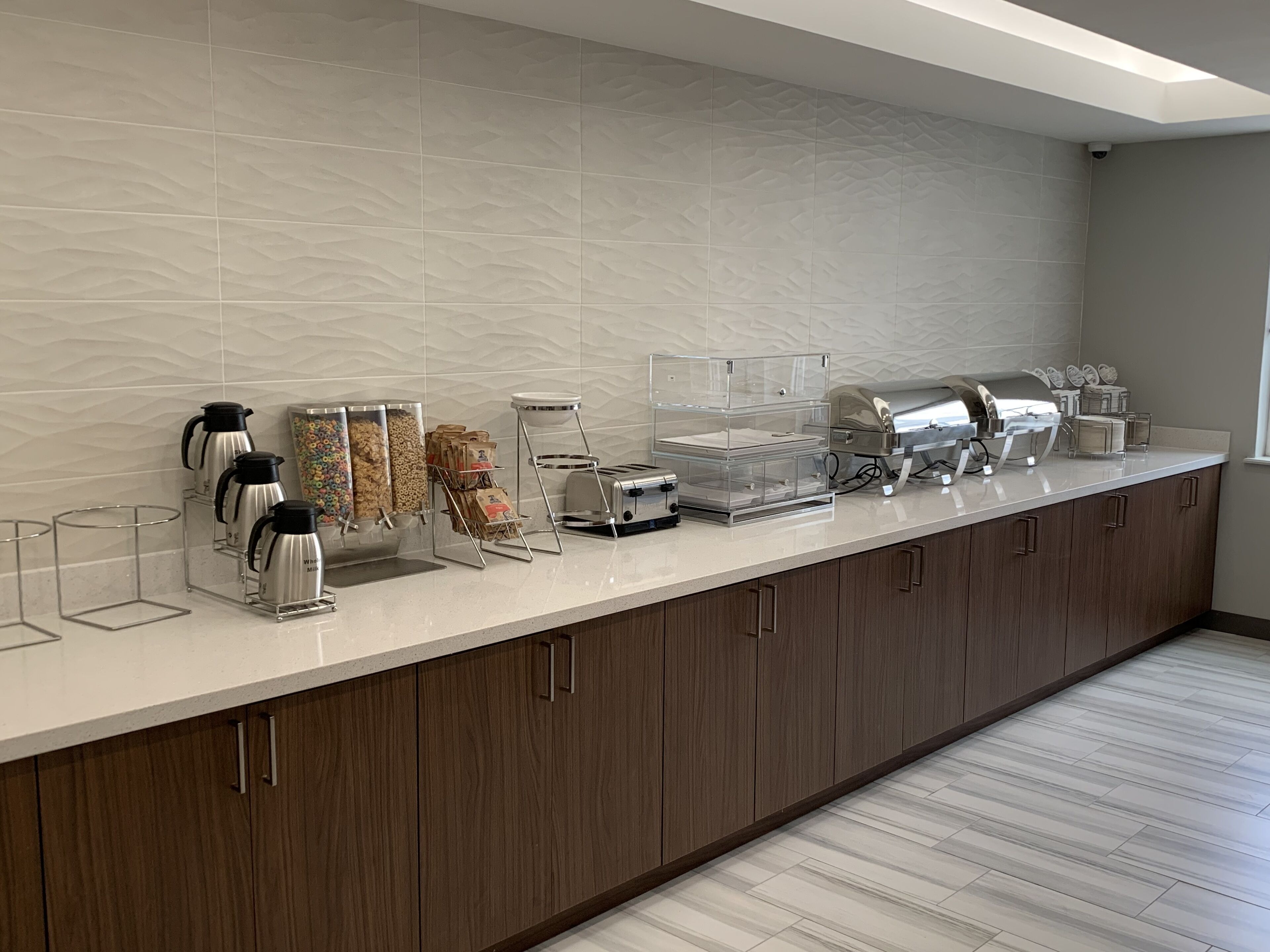 A breakfast bar with coffee makers, a toaster, and a grill.