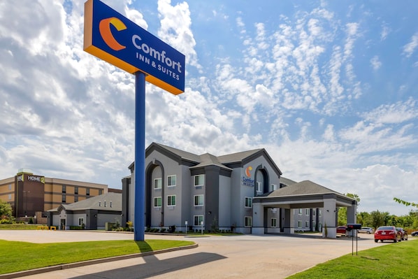 A Comfort Inn & Suites hotel with a modern architectural design, featuring a central courtyard and a parking area.