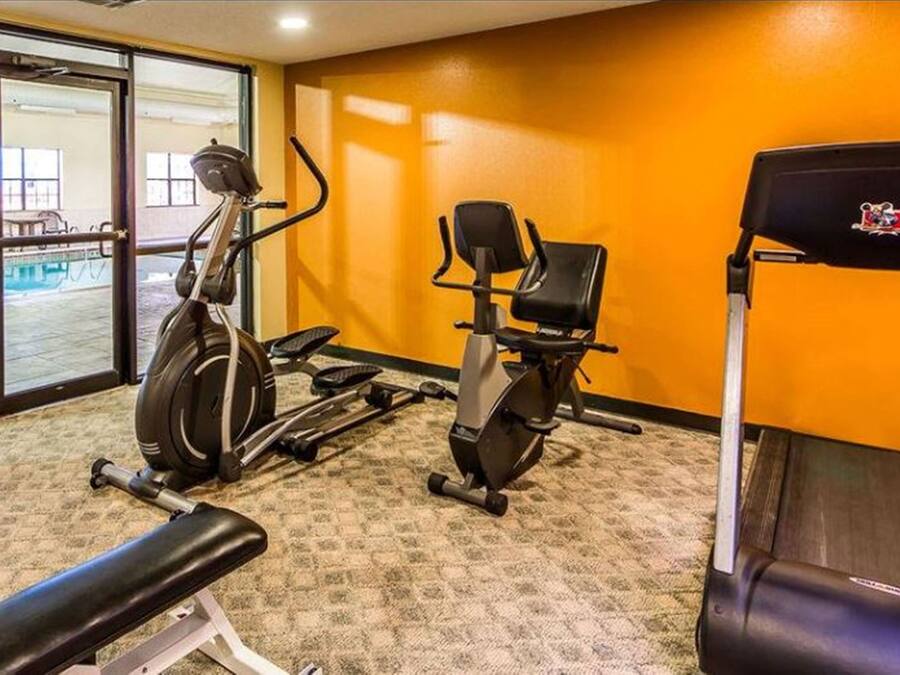 A gym with exercise equipment including a treadmill, elliptical, and stationary bike.