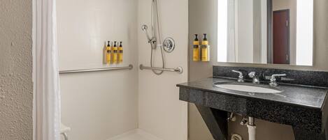 A bathroom with a shower, a sink, and toiletries on the wall.