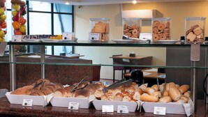 A buffet counter with various baked goods and pastries displayed in clear containers. - Rede Andrade LG Inn (Recife)