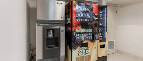 Máquina automática de venda com dispensador de água e máquina de bebidas com a etiqueta 'Smart Snacks Naturals 2GO'.