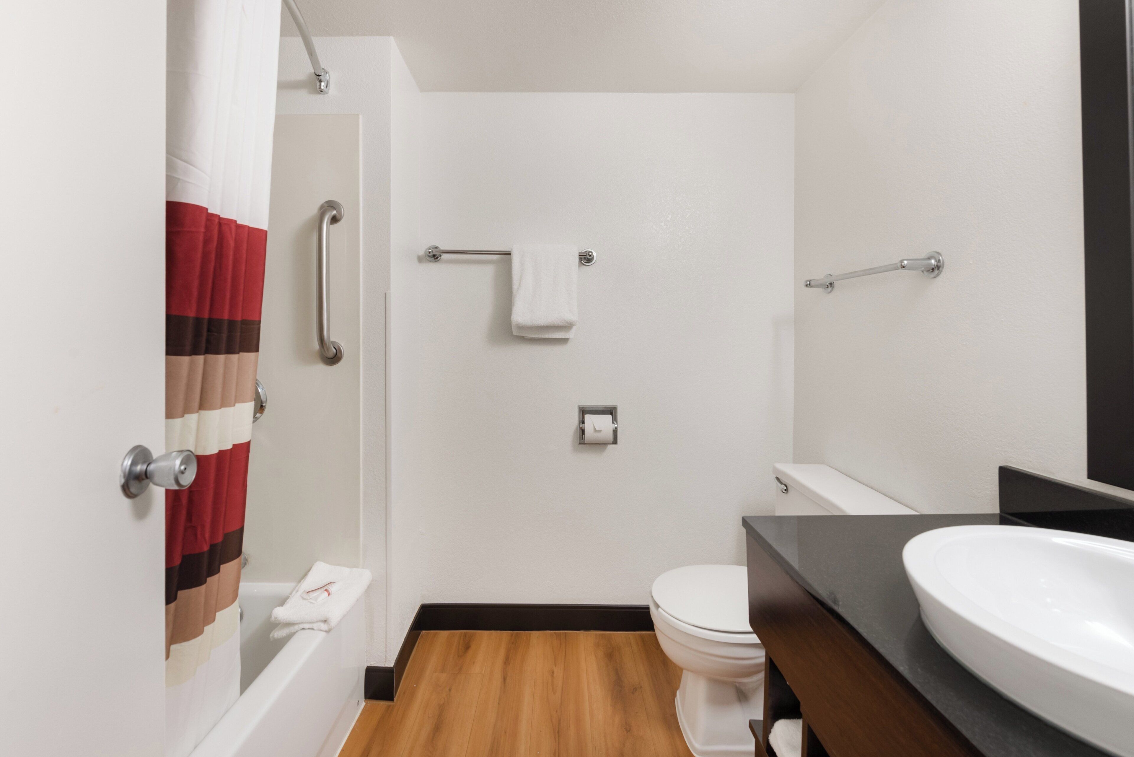 A bathroom with a shower, toilet, and sink.