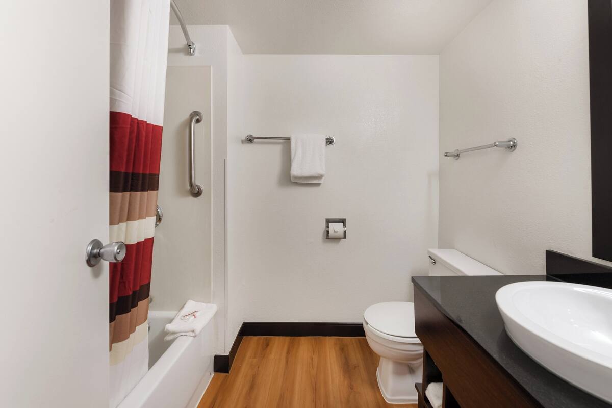 A bathroom with a shower, toilet, and sink.