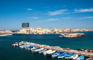 A harbor with boats docked, a large building, and a clear blue sky. - Bellavista Club - Caroli Hotels (Gallipoli)