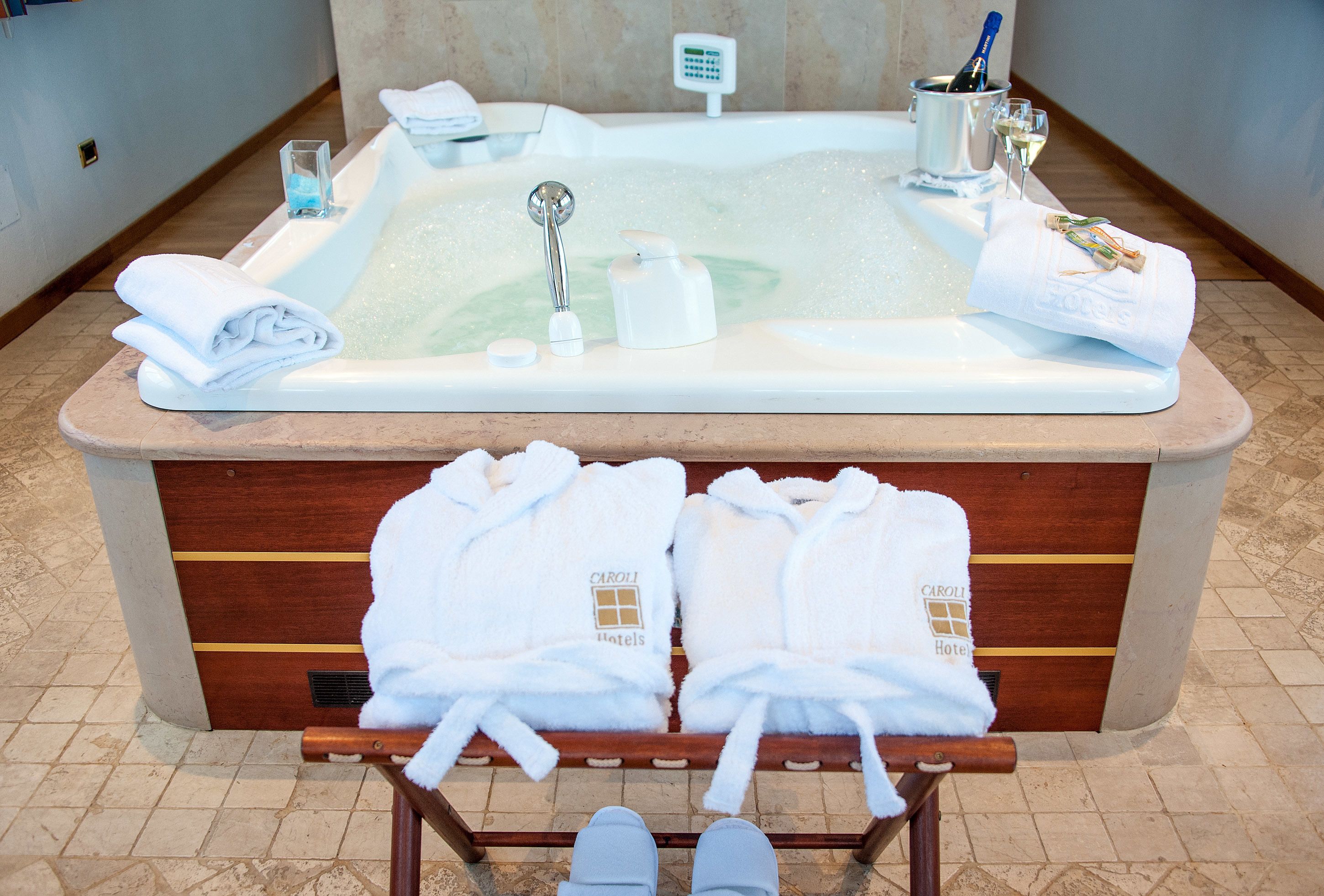 Une salle de bain d’hôtel équipée d’une baignoire, de serviettes et de produits de toilette.