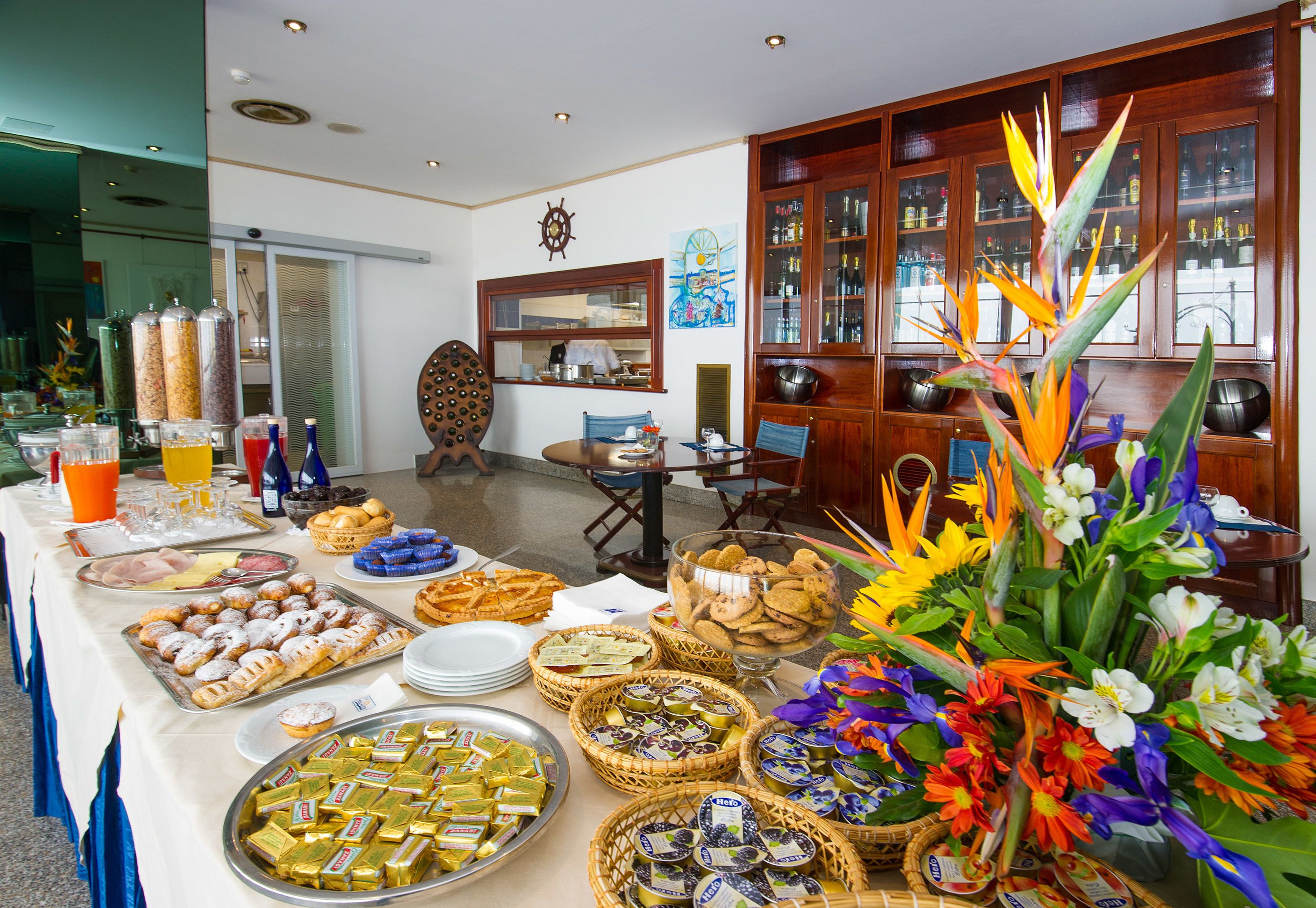 A buffet table with various food items and a decorative floral arrangement.