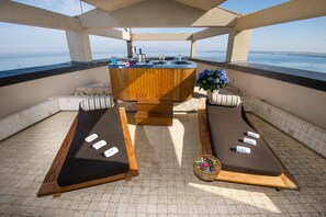 A rooftop terrace with a hot tub, two sun loungers, and a view of the sea. - Bellavista Club - Caroli Hotels (Gallipoli)
