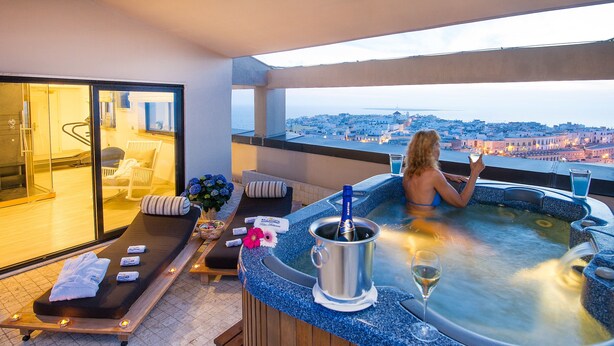 Boblebad med udsigt over byen, en massagestol og en flaske champagne.
