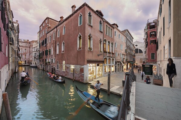 Un canal en Venecia con góndolas, edificios históricos y un paseo peatonal.