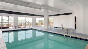 A swimming pool with clear blue water, surrounded by white walls and large windows. - Hampton Inn & Suites Denver - Cherry Creek (Glendale)