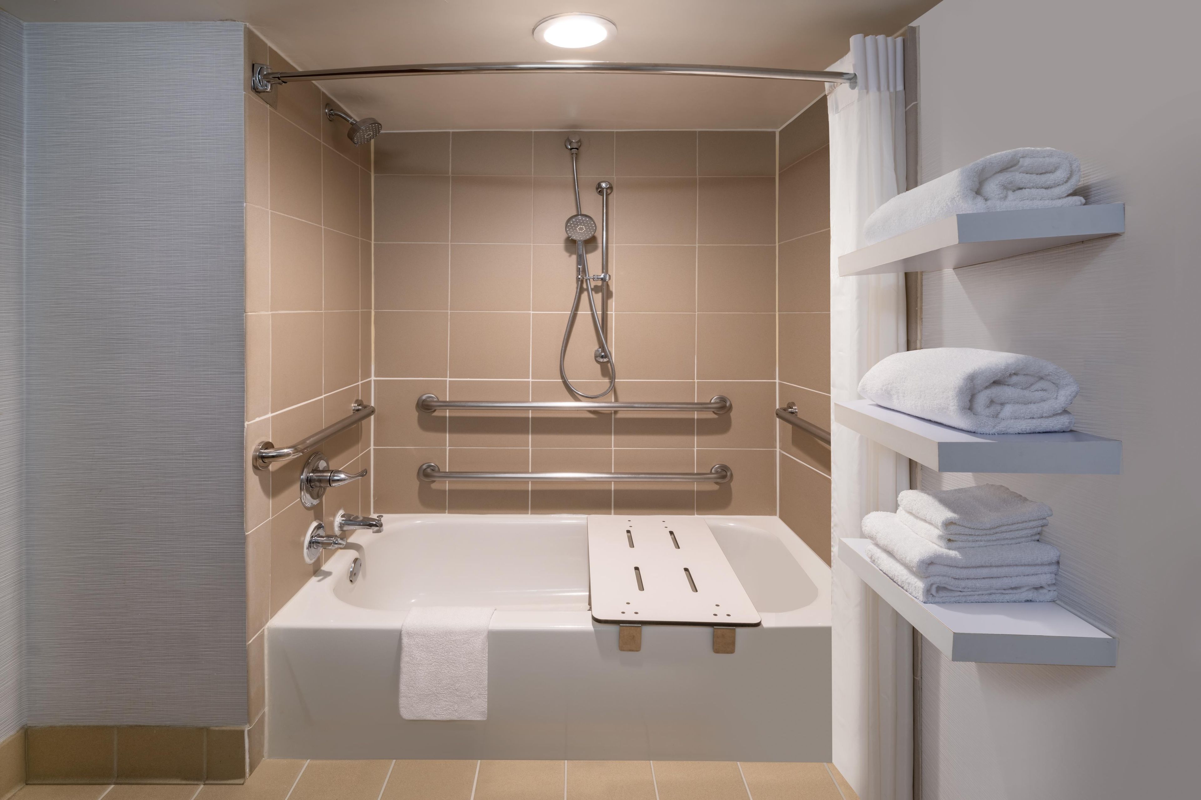 Une salle de bain moderne équipée d’une baignoire, d’une douche et d’un porte-serviettes.