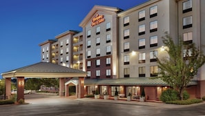 A multi-story hotel with a prominent sign, a covered entrance, and a parking area. - Hampton Inn & Suites Denver - Cherry Creek (Glendale)