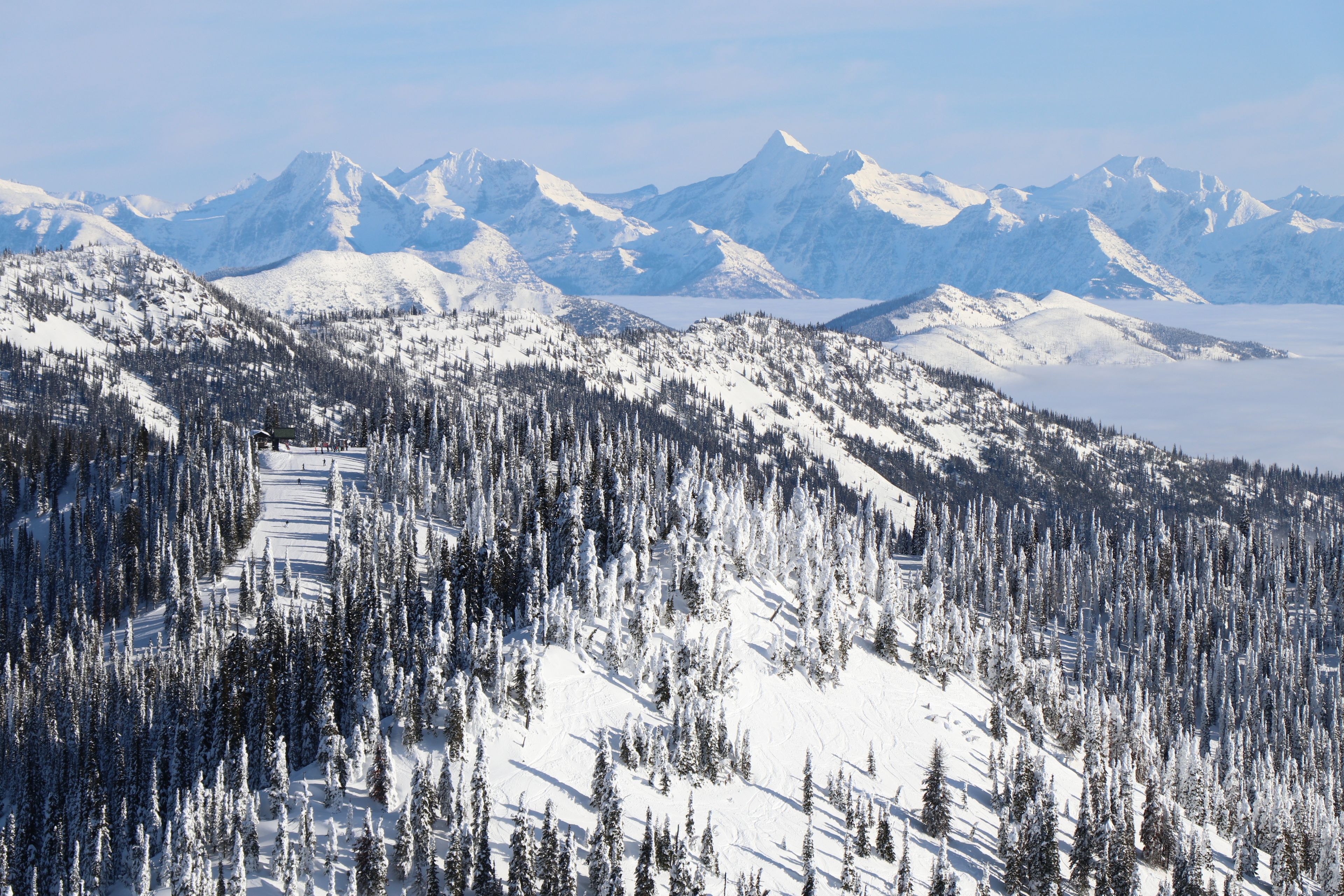 A snow-covered mountain landscape with a ski trail.
