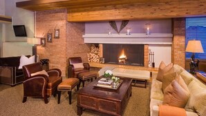 Una sala de estar acogedora con chimenea, sofás de cuero y una mesa de centro.
