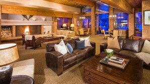 A spacious living room with leather sofas, a fireplace, and a dining area.