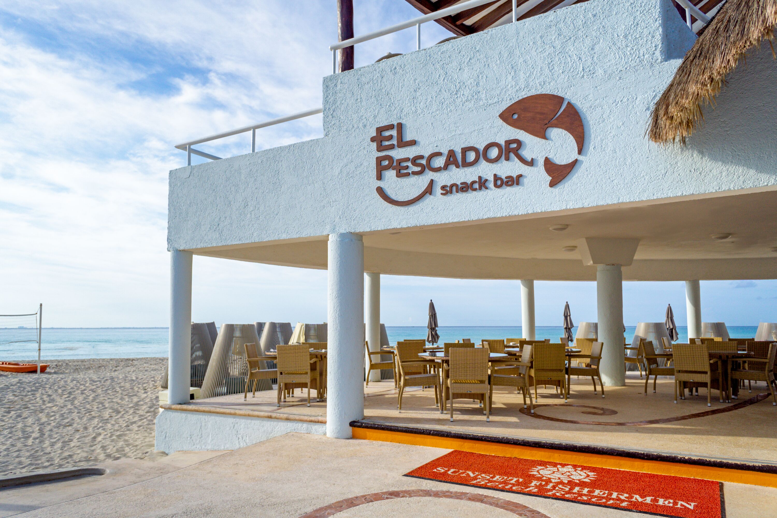 Eine Strandbar namens "El Pescador" mit Außenbereich und Blick auf das Meer.