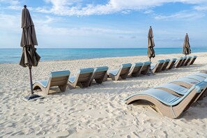 On the beach, white sand, sun loungers, beach umbrellas