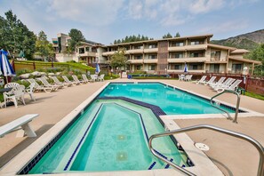 Una piscina al aire libre, sillones reclinables de piscina