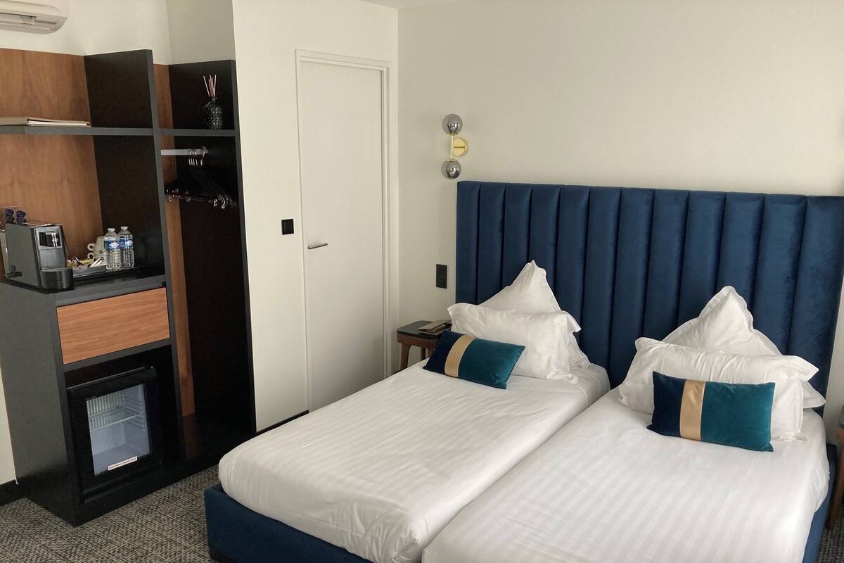 Hotellihuone, jossa on sänky, työpöytä kahvinkeittimellä sekä vaatekaappi.