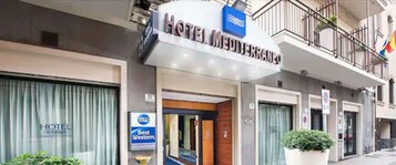 Un hotel llamado "HOTEL MEDIERRANO" con un letrero que indica que pertenece a la cadena de hoteles Best Western.