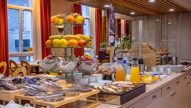 A breakfast buffet with various fruits, cereals, and beverages.