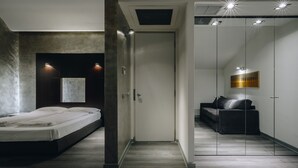 Une chambre moderne comprenant un lit, une armoire et un coin salon.