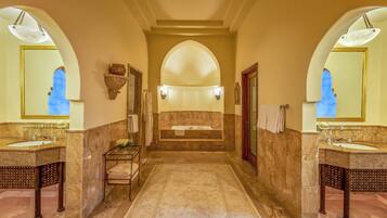A luxurious bathroom with two sinks, a large mirror, and a marble floor.