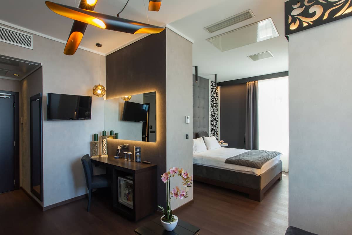 Ein modernes Hotelzimmer mit Bett, Schreibtisch und Fernseher.