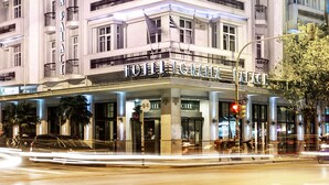 Ein mehrstöckiges Hotel mit klassischer Architektur, mit Balkonen und großen Fenstern.