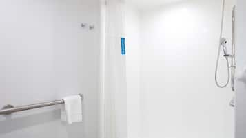 Un baño moderno con cabina de ducha de vidrio, toallero y ducha de mano.