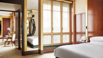 Une chambre d’hôtel avec un grand lit, un bureau et une chaise. Il y a une fenêtre avec des rideaux et une vue sur l’extérieur.