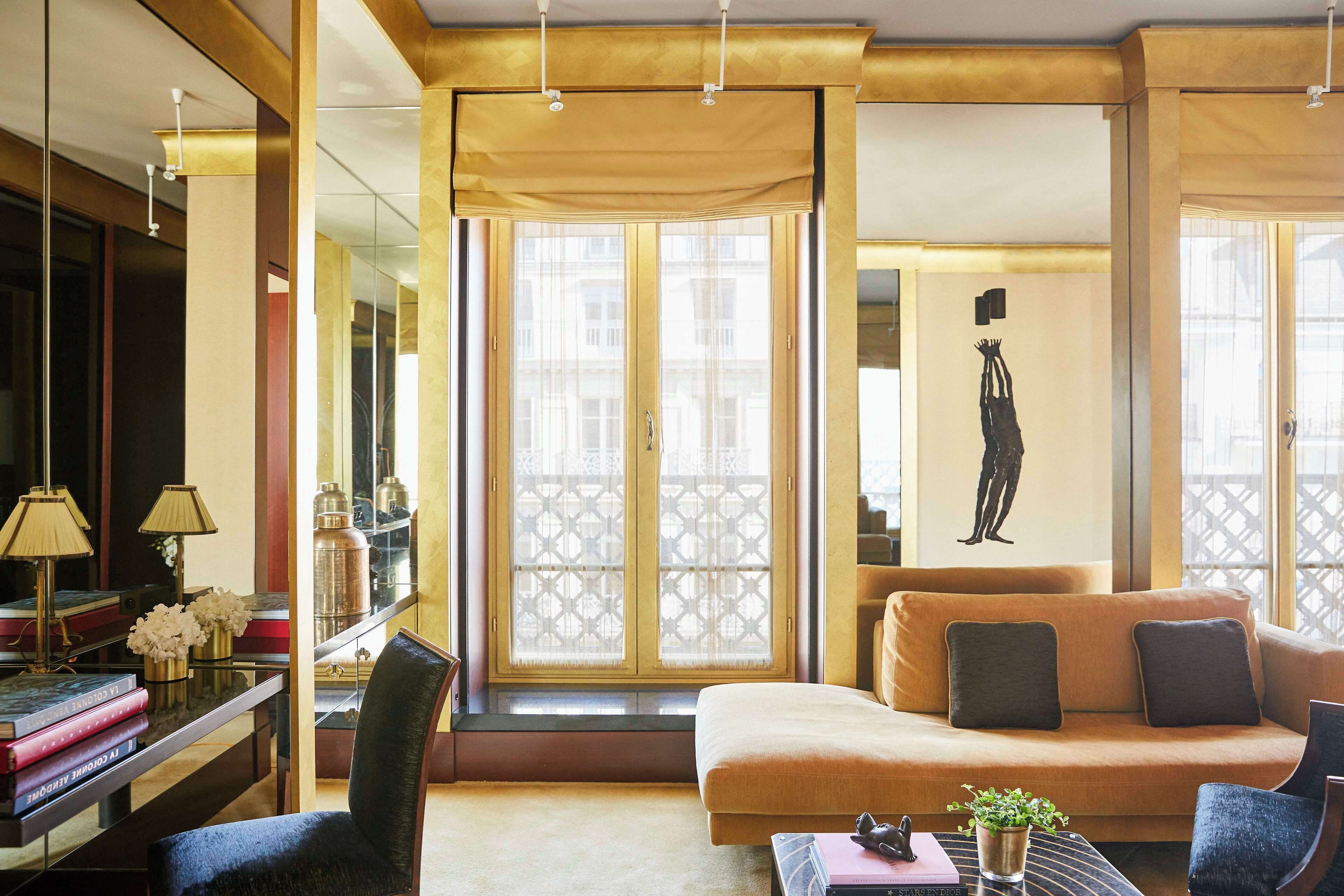 A modern living room with a sofa, armchairs, a coffee table, and a bookshelf.