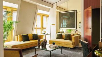 A modern living room with a sofa, armchairs, a coffee table, and a large mirror.