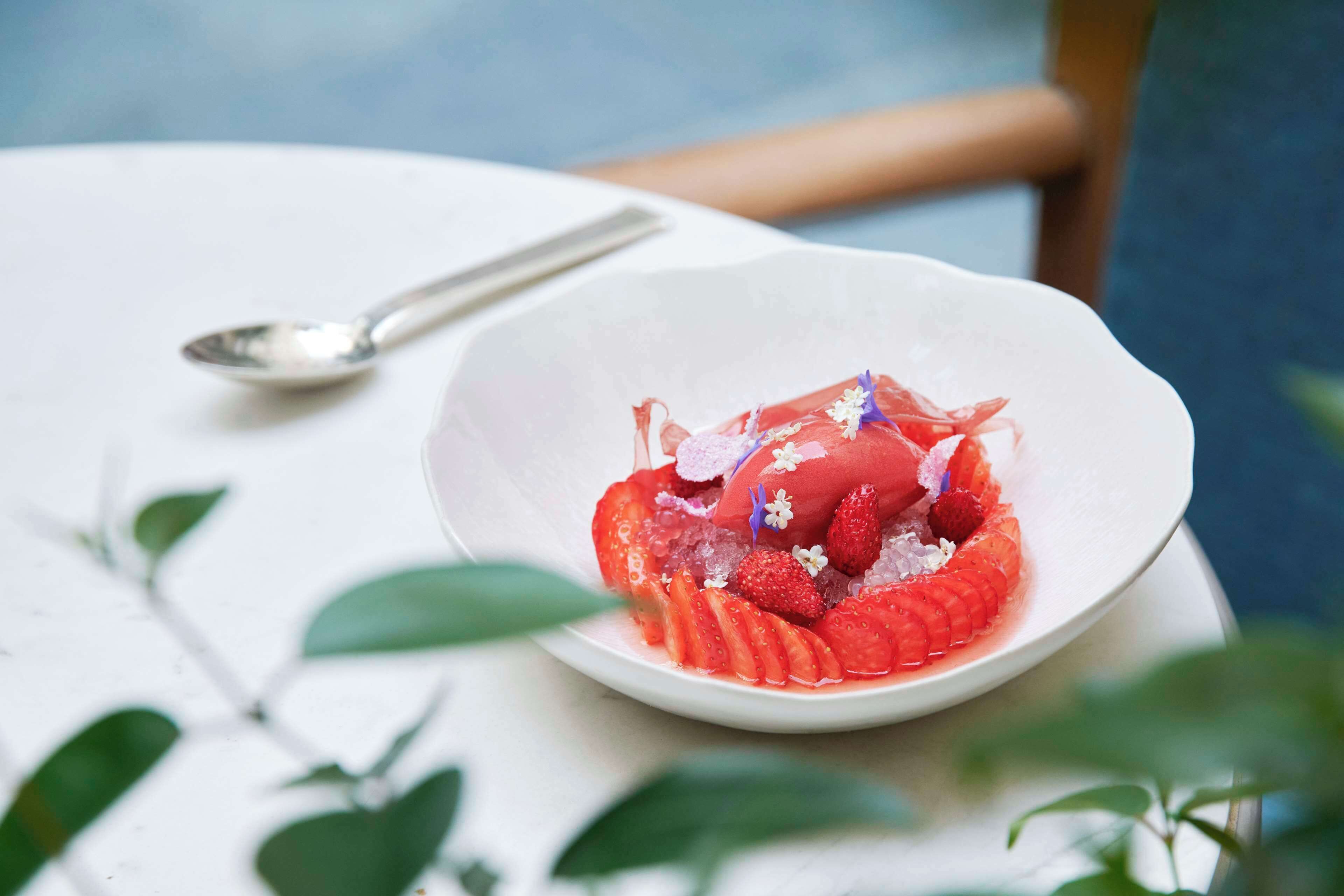 A white bowl with a dessert on a white table.