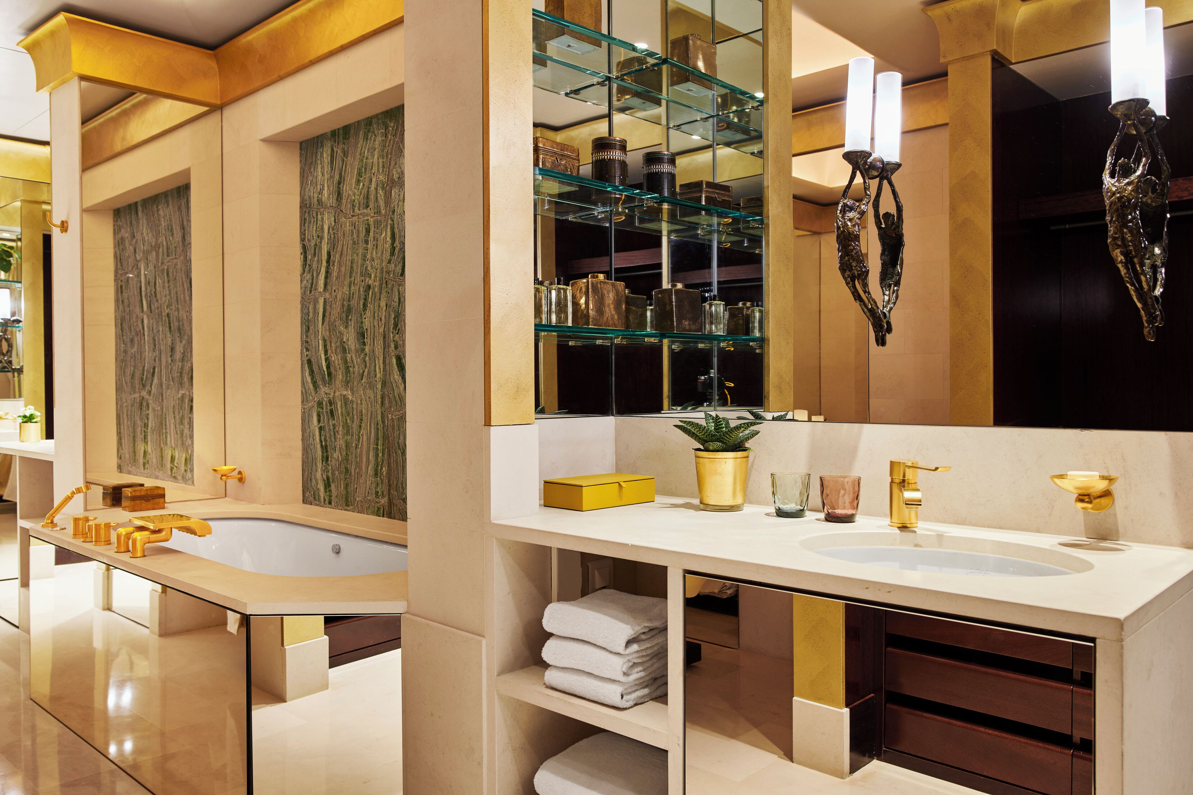 A modern bathroom with a large mirror, two sinks, and a glass display cabinet.