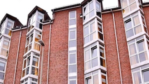 Un edificio de ladrillo de varios pisos, con ventanas grandes y un garaje.