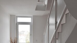 Una escalera moderna con barandillas de metal y vistas a una zona residencial.