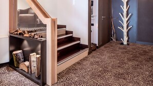 Un interior moderno con una escalera, decoración de pared de madera y una alfombra con estampado de cebra.