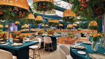 A banquet hall with round tables, chairs, and hanging lanterns.