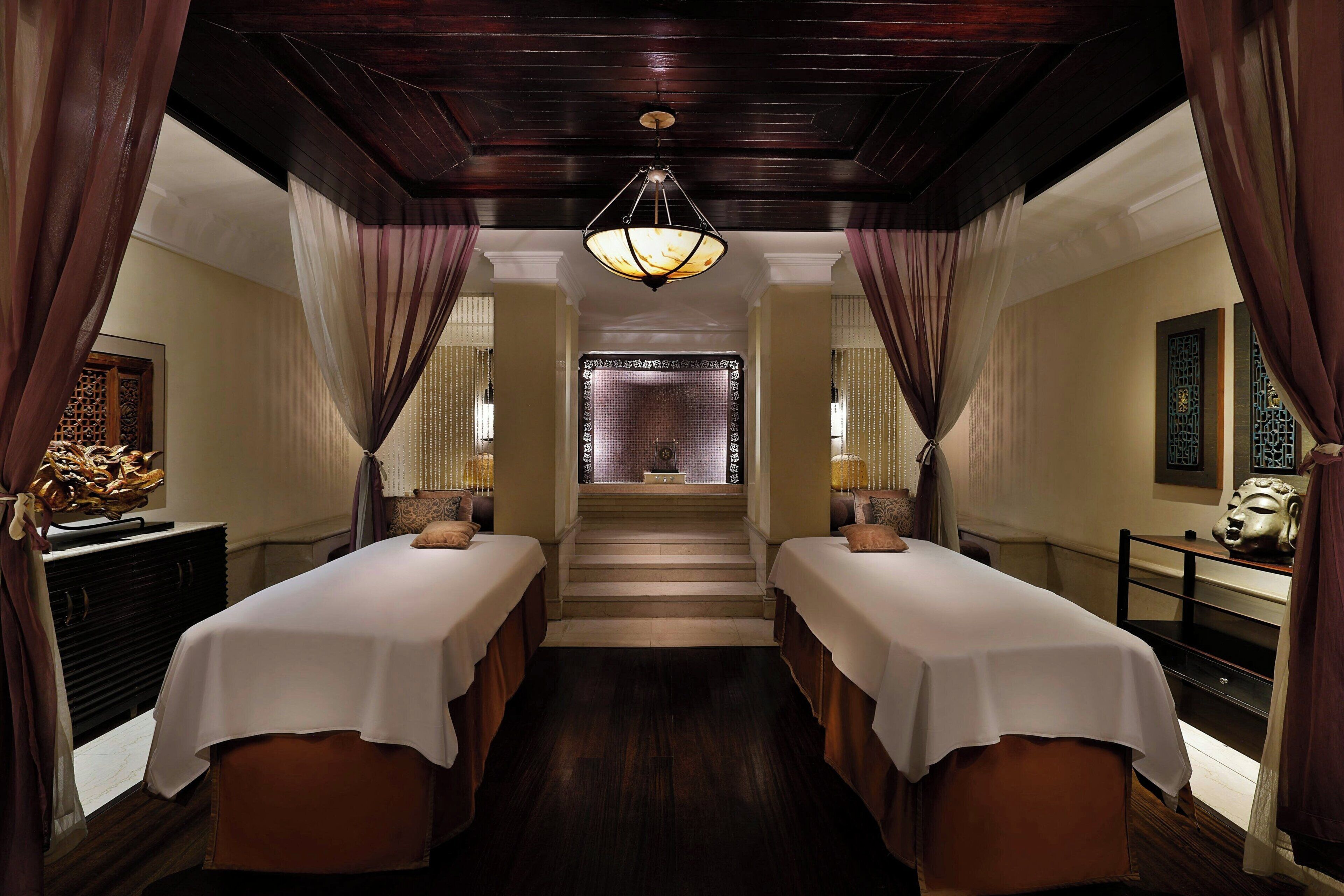 A hotel room with two beds, a staircase, and a view of a traditional building.