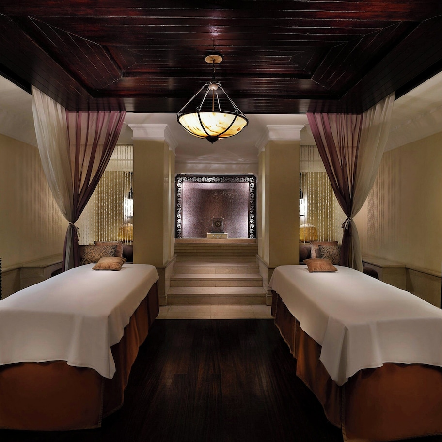 A hotel room with two beds, a staircase, and a view of a traditional building.